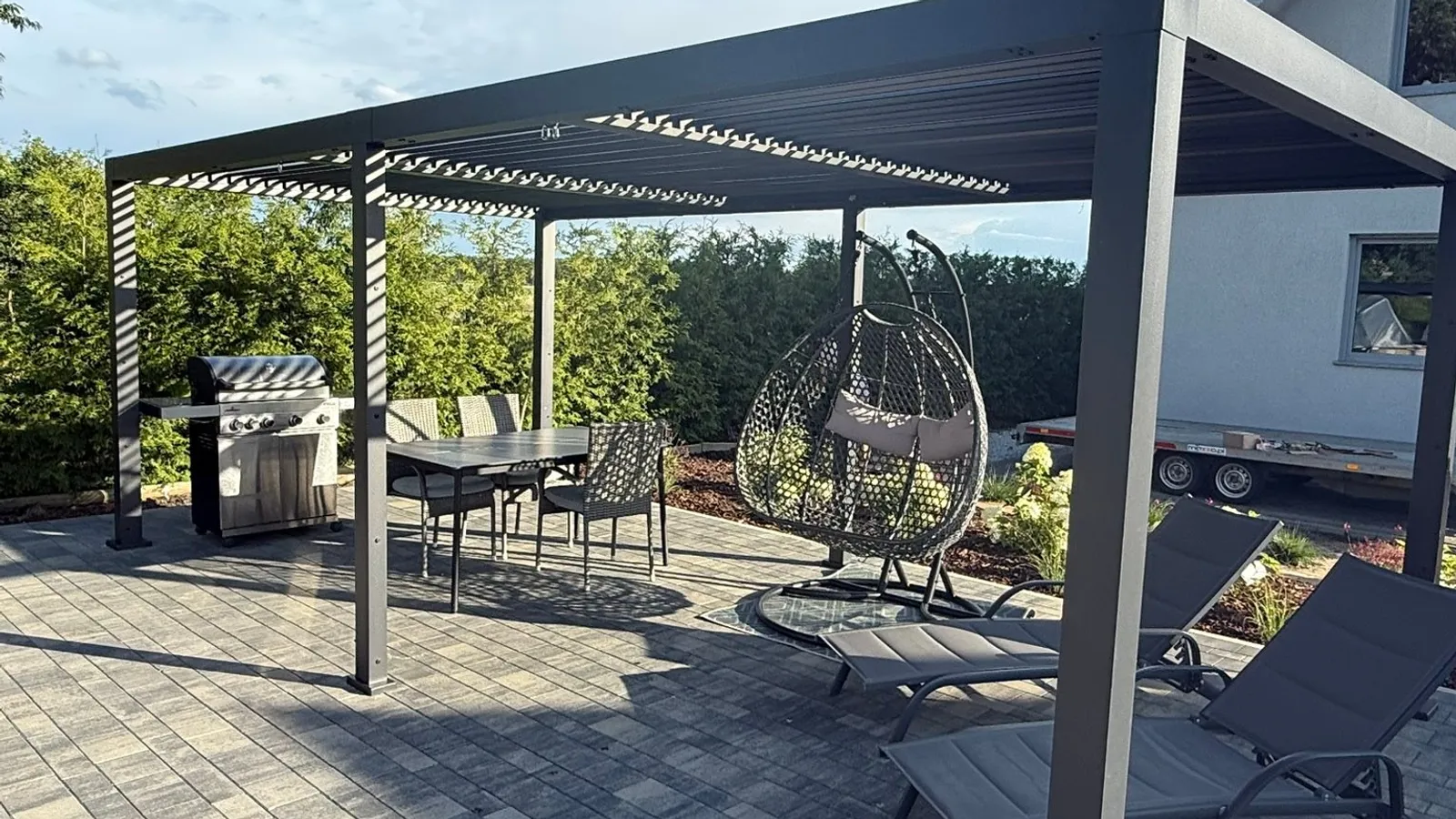 Antracytowa pergola nad tarasem z meblami ogrodowymi - realizacja MKM EXPERT